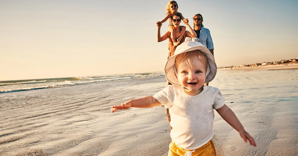 baby-running-with-family-on-beach